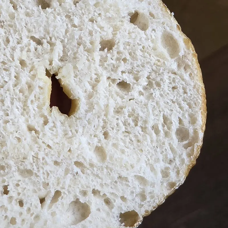 A sourdough bagel cut open to show the soft inside
