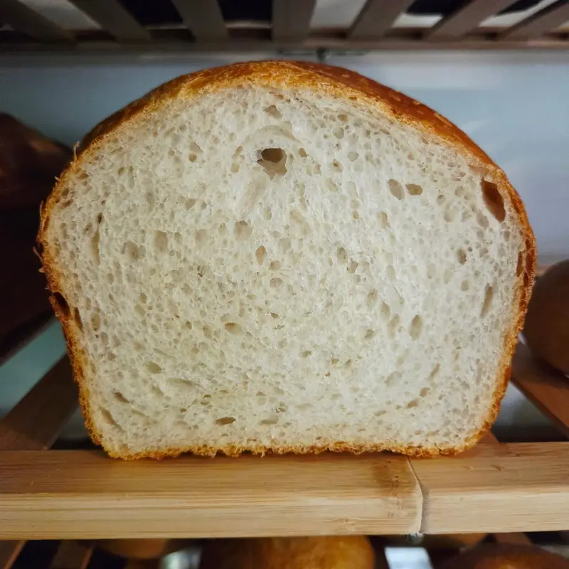 A slice of sandwich bread on a wooden shelf